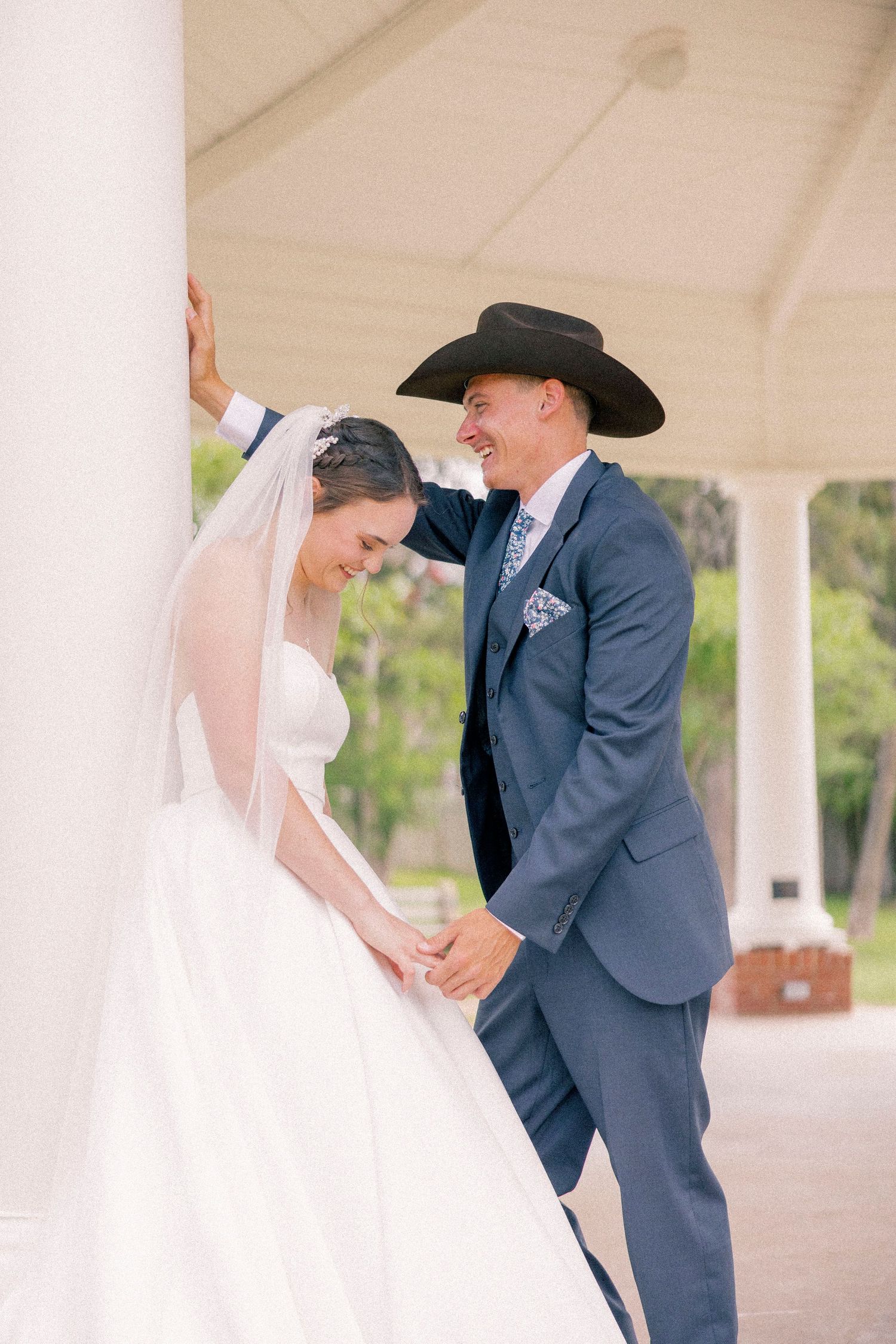 Wedding couple sharing romantic moment under white pavilion.