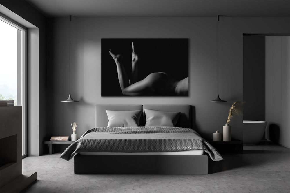 Modern grey bedroom interior with large black and white figure art print above bed.
