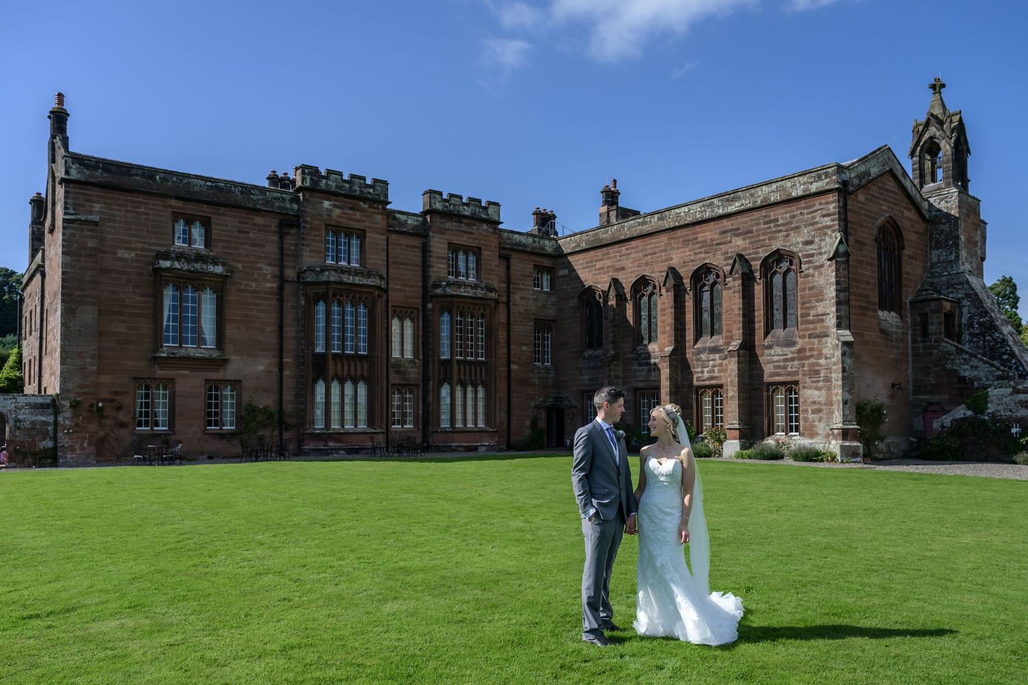 Bride and groom on lawn at Rose Castle in Cumbria