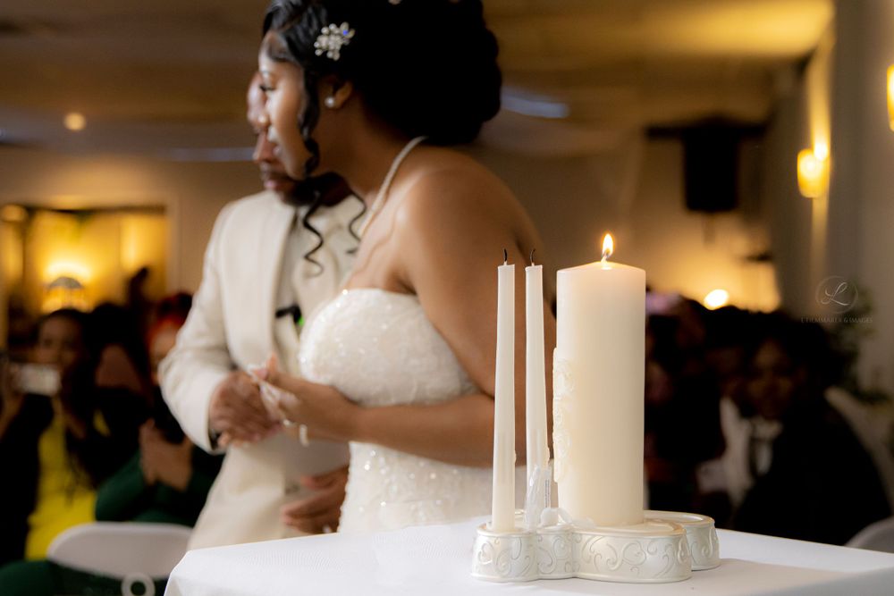 Wedding ceremony setting with white candles and formal attire.