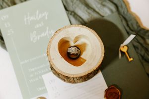 Rustic wooden ring boxes with gold wedding bands displayed on white surface.