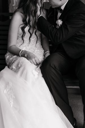 Close-up details of elegant wedding attire in black and white.