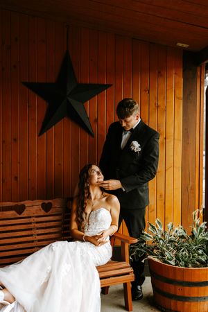 Romantic wedding portraits on wooden porch with rustic barrel and star decorations.