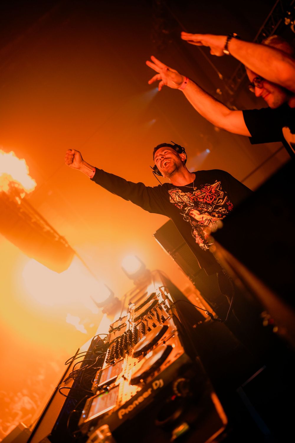 DJ performance setup illuminated in warm orange lighting during an electronic music event.