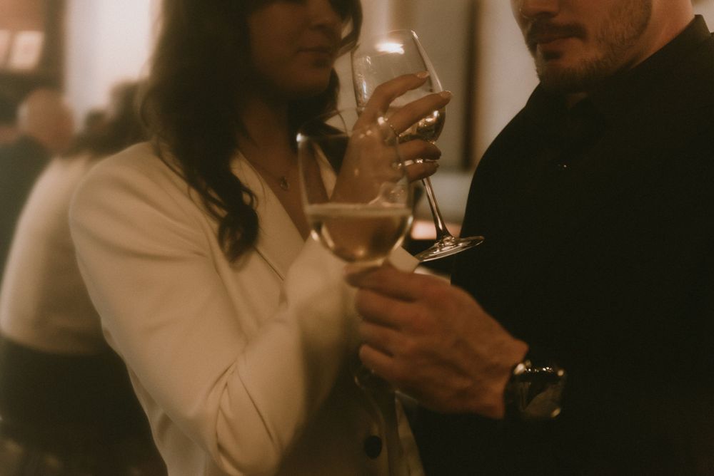 A couple toasting with wine glasses in a romantically lit setting, capturing an intimate moment.