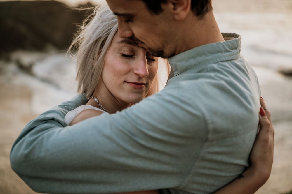 A tender close-up moment captured between two people in soft, warm lighting.