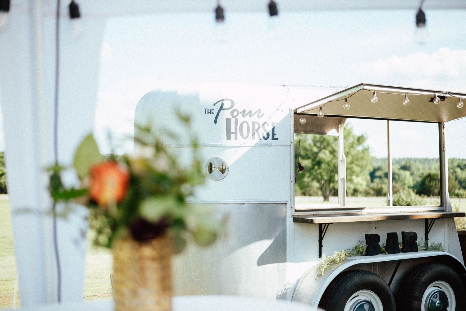 Outdoor wedding venue setup with string lights and rustic decor.