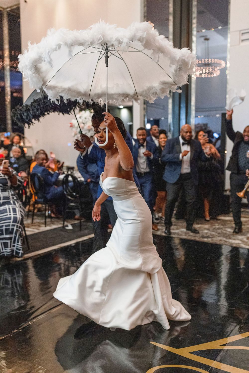 Bride dances with decorative white parasol during wedding reception celebration.