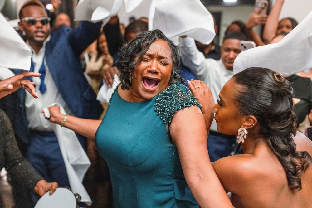 Wedding guests celebrate joyfully on the dance floor during an energetic reception celebration.