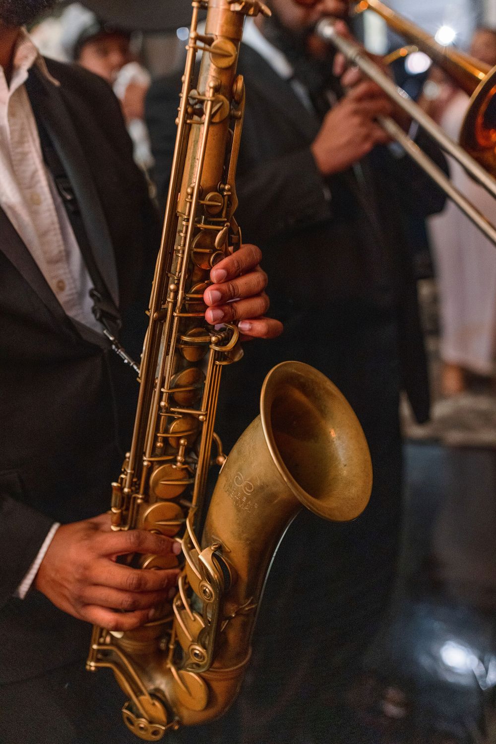 Close-up shot of musician holding brass saxophone during performance.