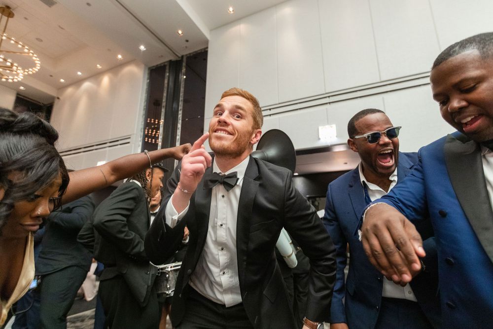 Wedding guests laughing and dancing together during a joyful reception celebration.