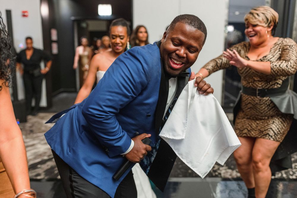 Guest dancing enthusiastically at a wedding reception while holding a white handkerchief.