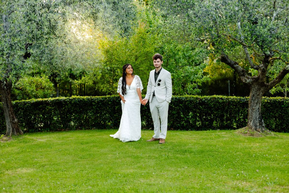 Wedding couple poses for romantic portraits in lush green garden setting.