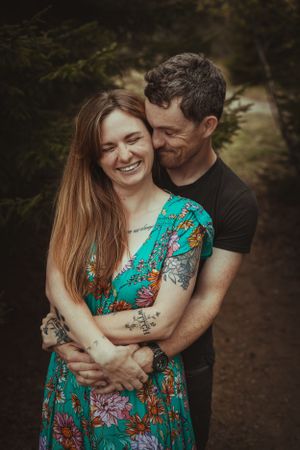 A romantic moment in the forest with a turquoise floral dress and black shirt.