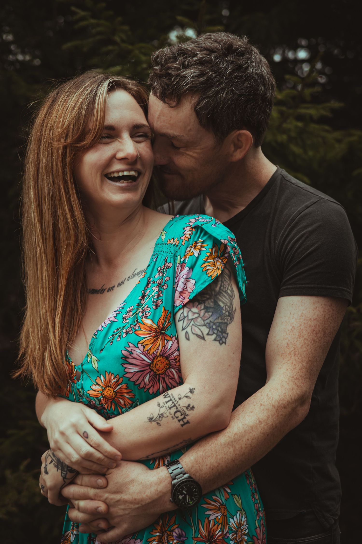 A tender embrace showing laughter and joy in a forest setting.