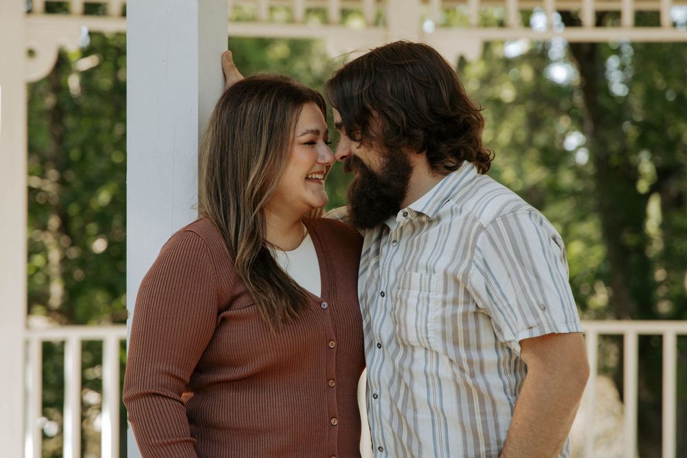 An intimate moment shared between a couple under a white gazebo.
