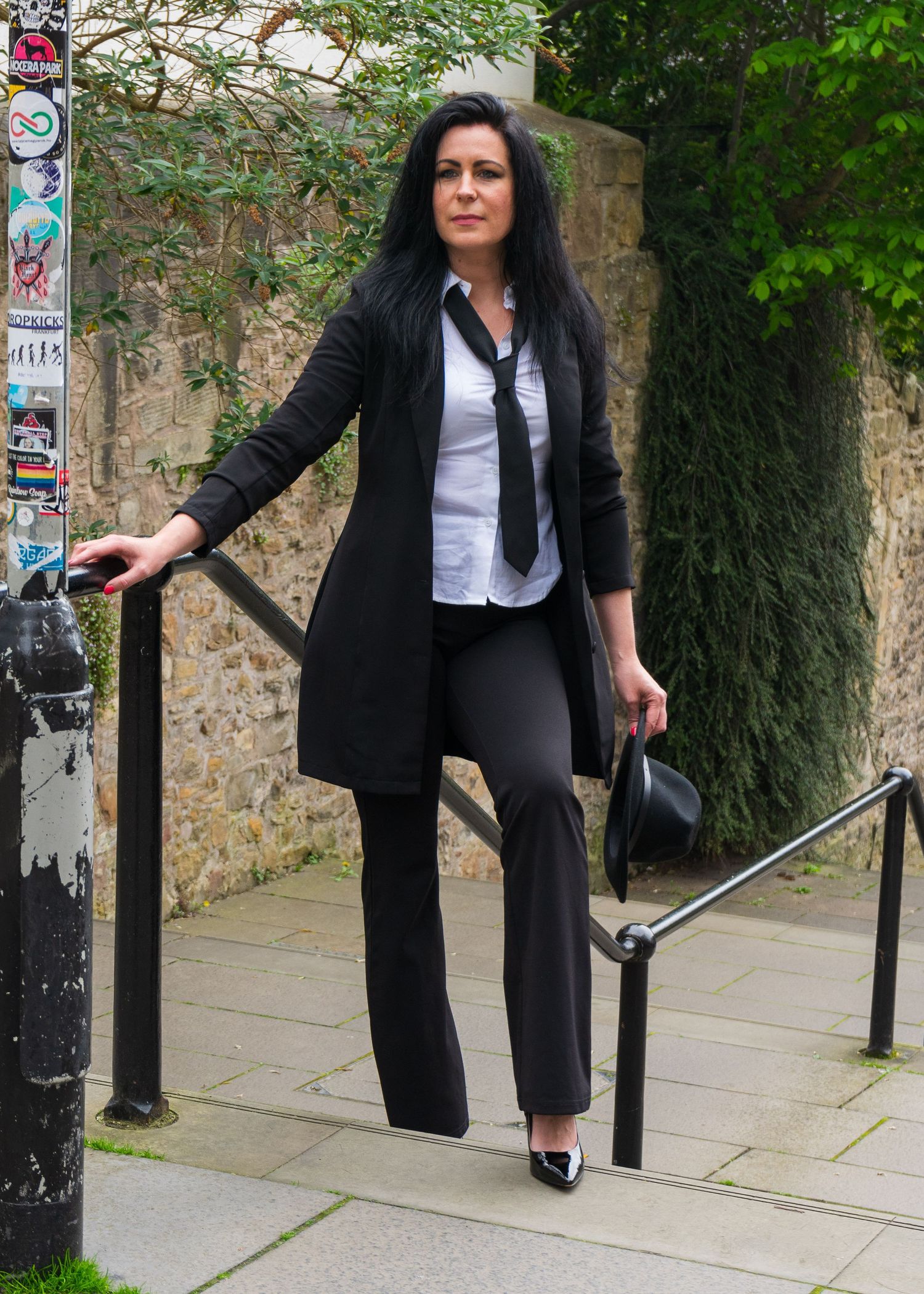 A figure in business attire walks along the stone wall path