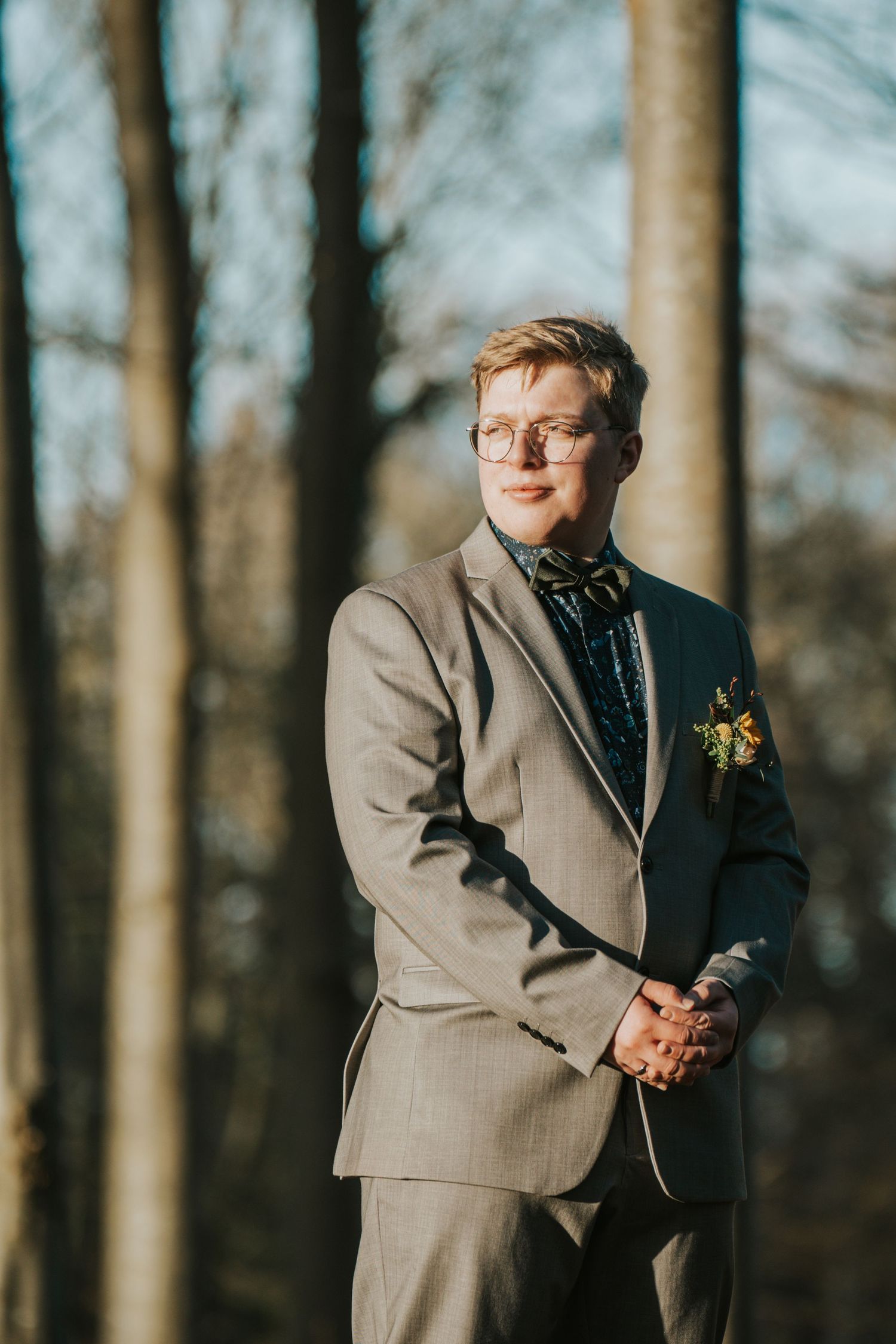 Wedding portraits in a wooded setting with warm natural lighting filtering through trees.