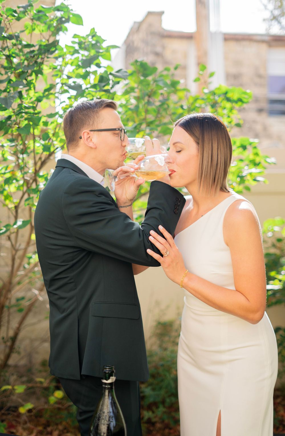 Bride and groom share a romantic champagne toast together at their intimate outdoor wedding celebration.