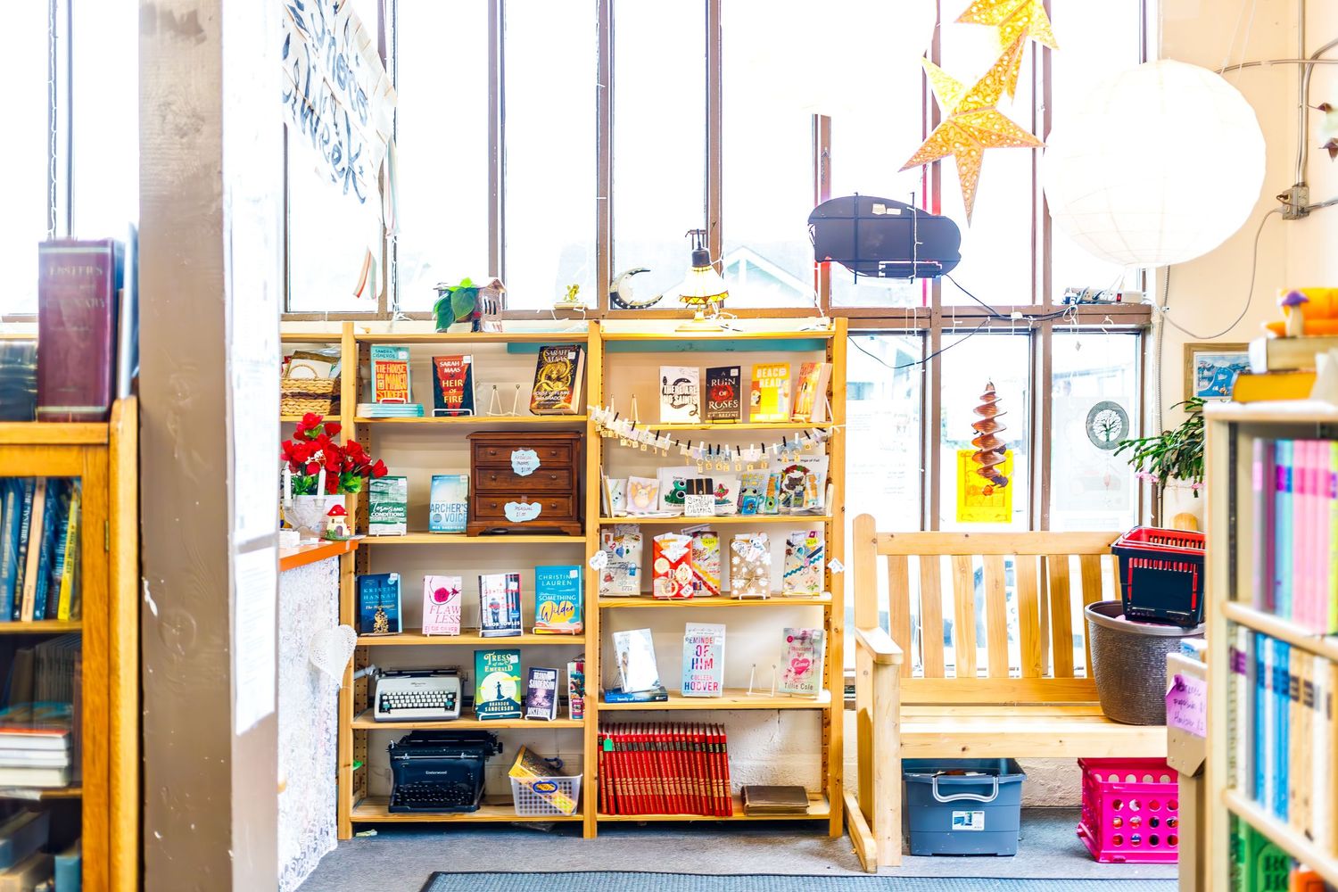 Bright bookstore corner with wooden shelving displaying children's books and decorative items.