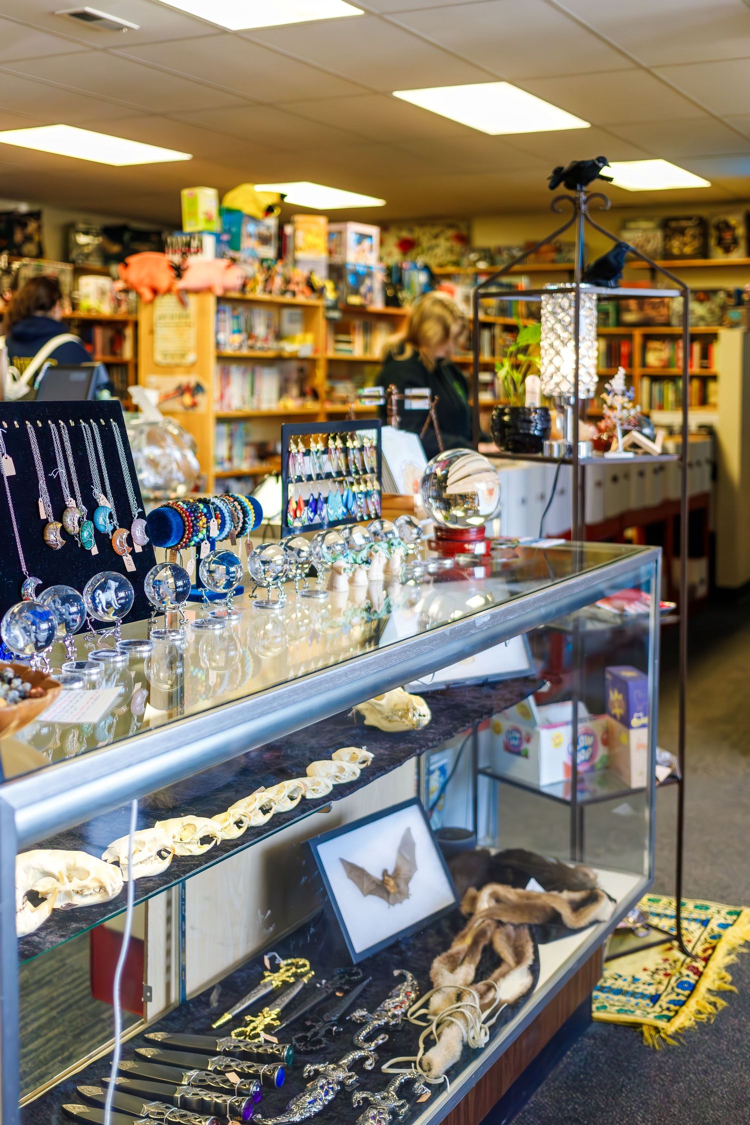 Glass display case filled with jewelry and accessories in independent bookstore.