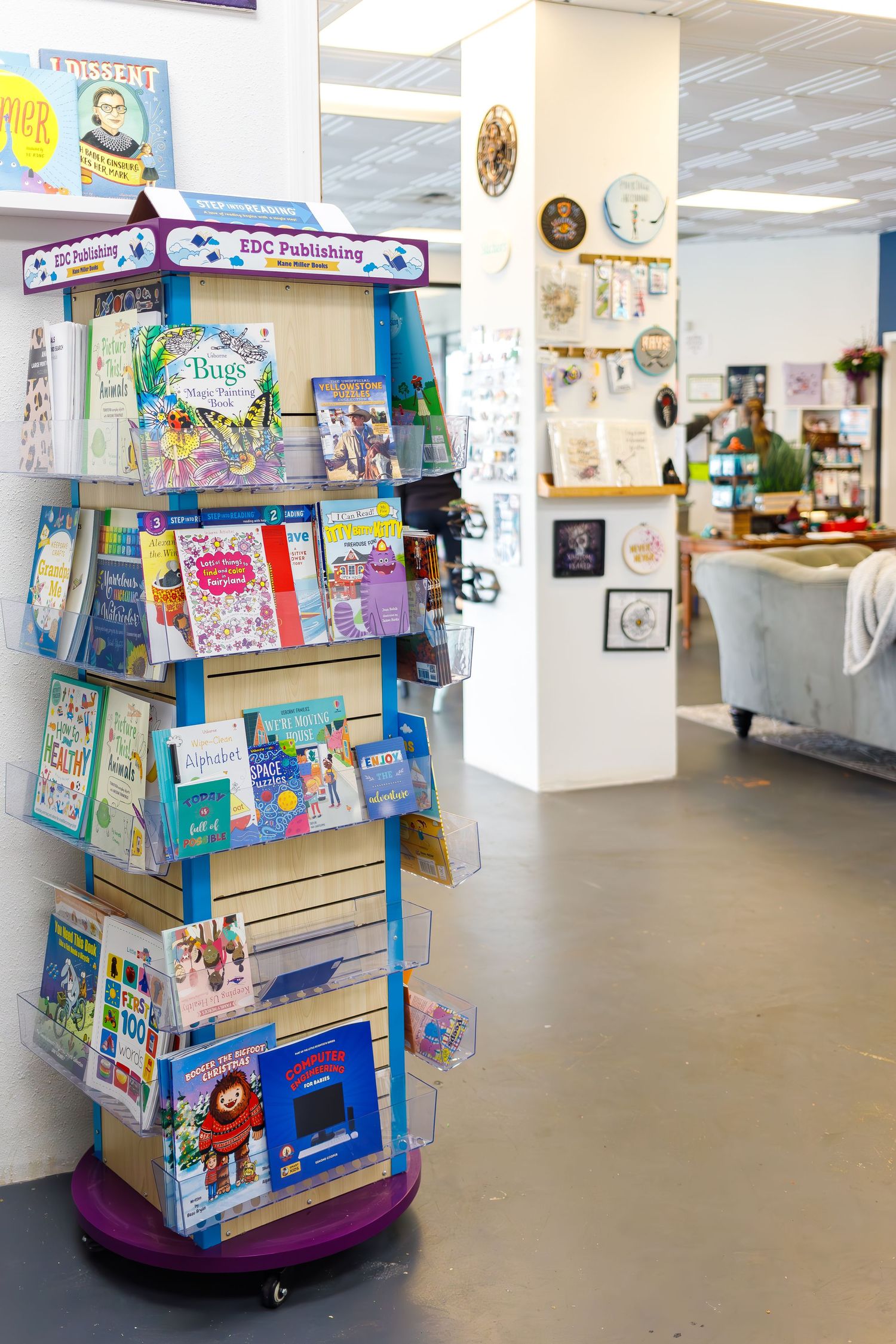 Rotating children's book display stand featuring colorful picture books and educational materials.