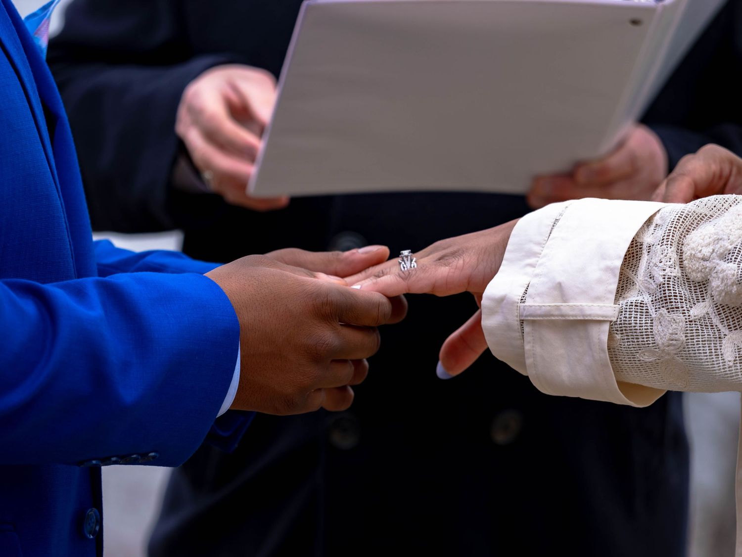A close up of hands exchanging paperwork during what appears to be a business or administrative transaction.