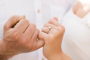 Close-up of two hands making a pinky promise gesture.