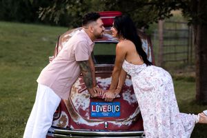 Couple shares intimate moments during an outdoor photoshoot with vintage props.