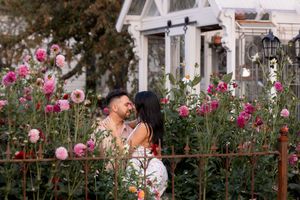 Romantic garden photoshoot with pink roses and vintage decor creating a dreamy atmosphere.