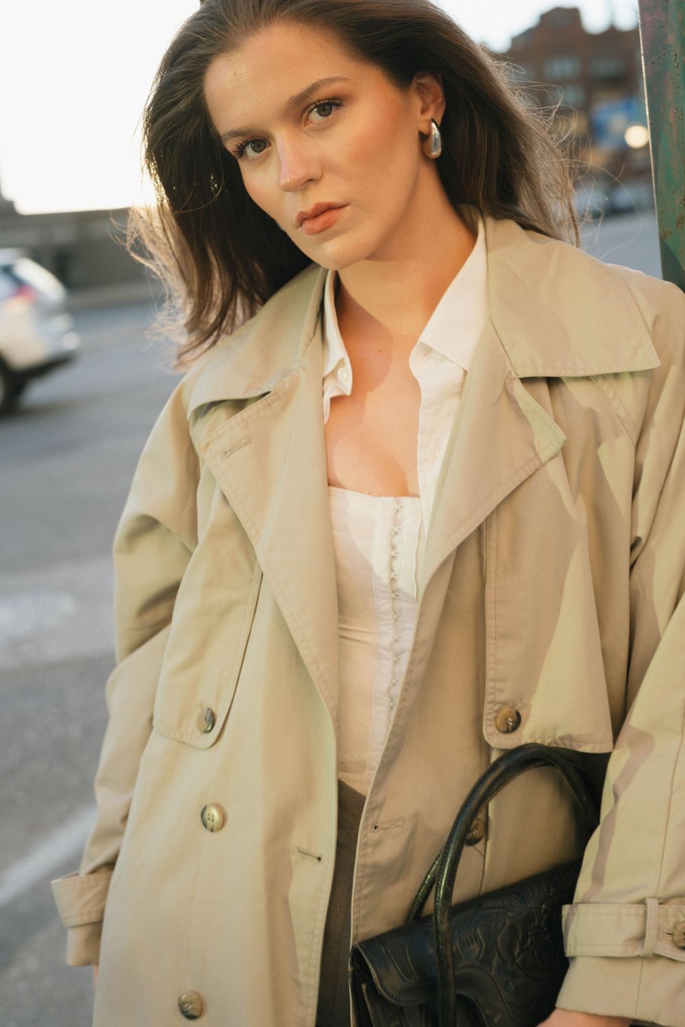 Portrait shot of someone in a beige trench coat and white blouse against an urban background.
Saskatoon Portrait Photographer
