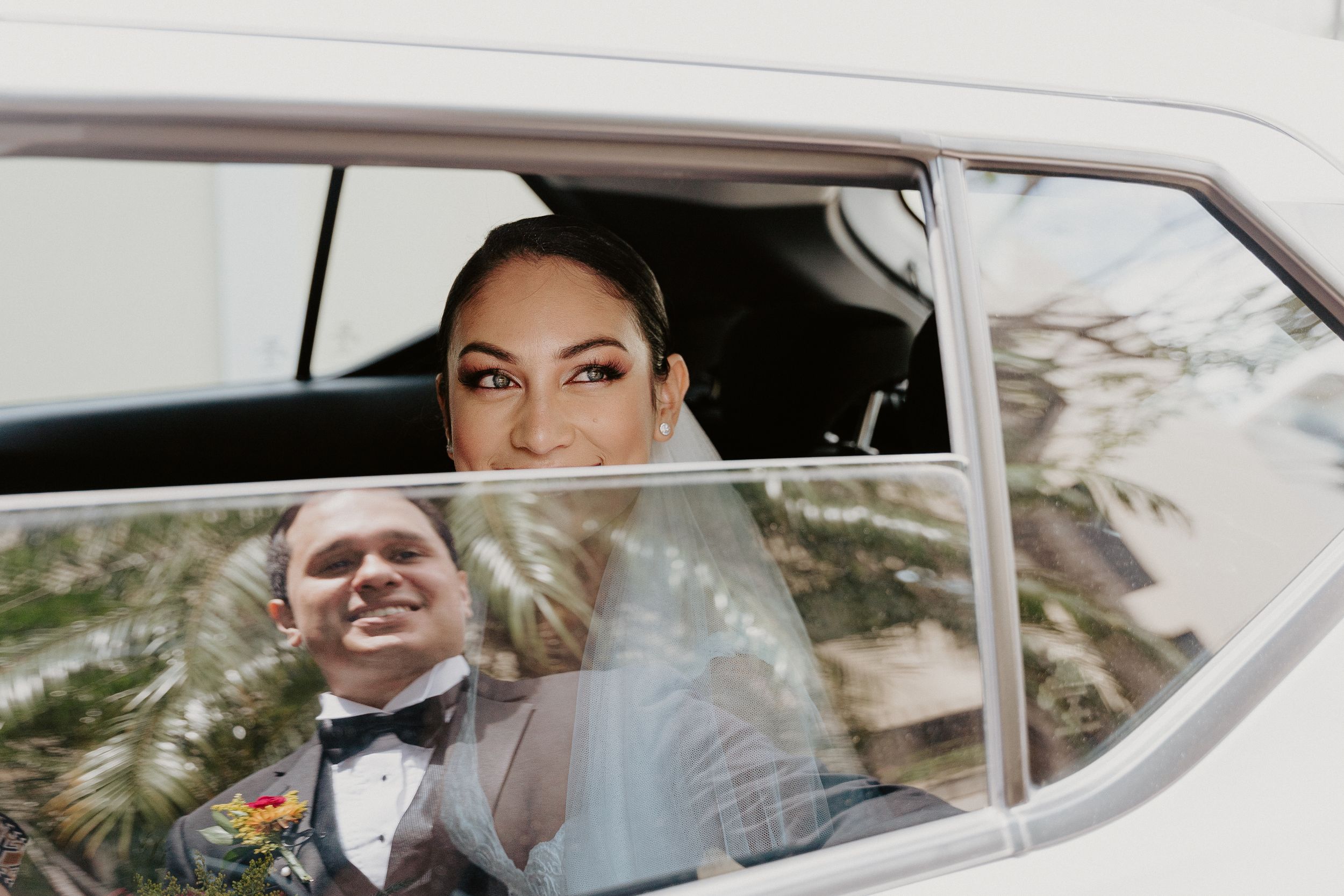 A wedding portrait through a classic car window framing the classic style of the day. San José, Costa Rica, Barrio amón, wedding photography