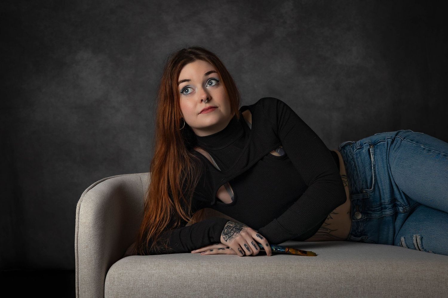 Artistic portrait sequence on dark couch with dramatic lighting.