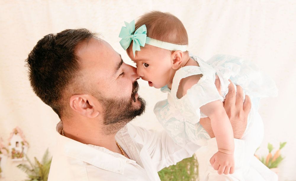 Tender moment between parent and baby wearing mint bow headband.