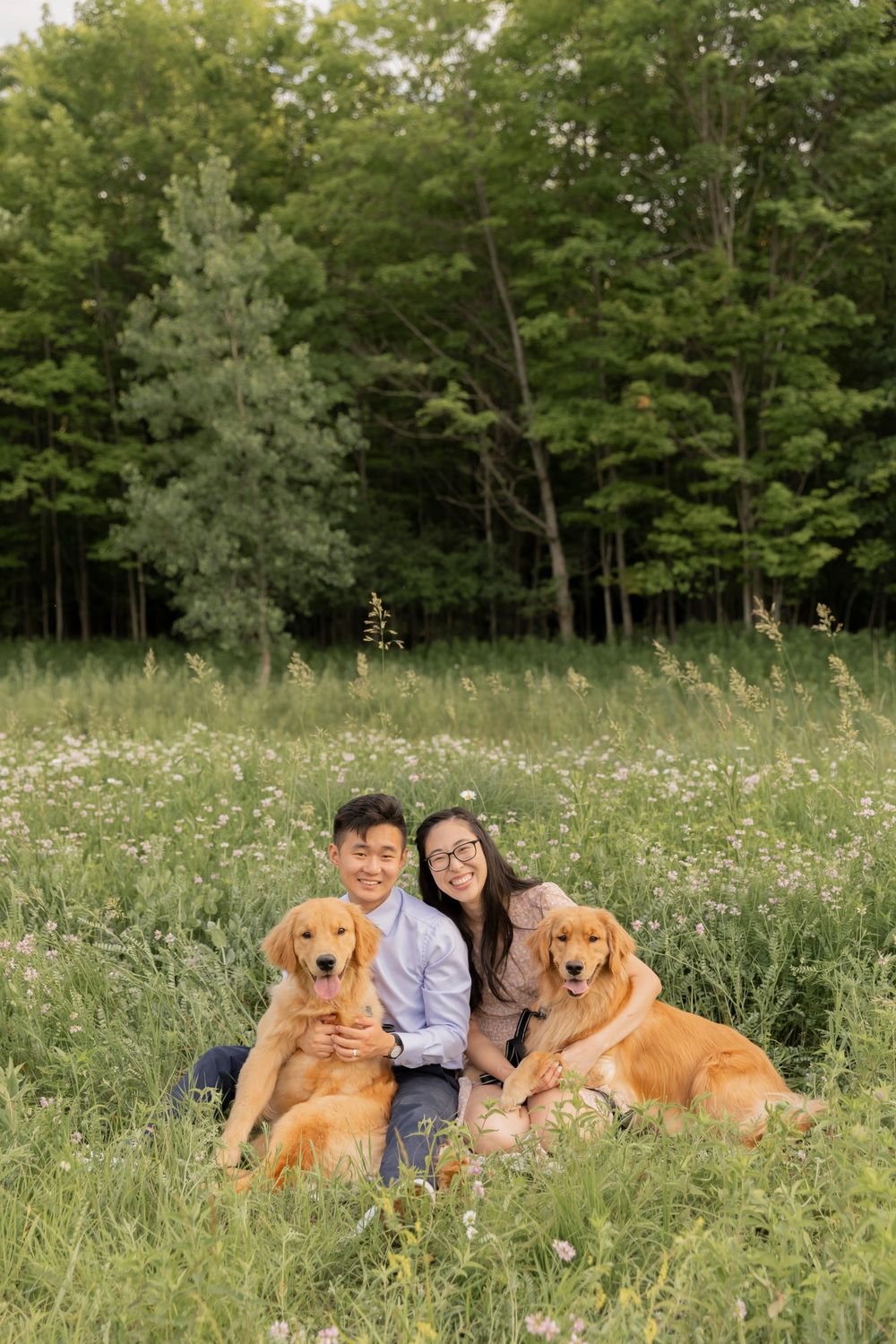 couple sitting is a field of grasses and wildflowers at a photoshoot location