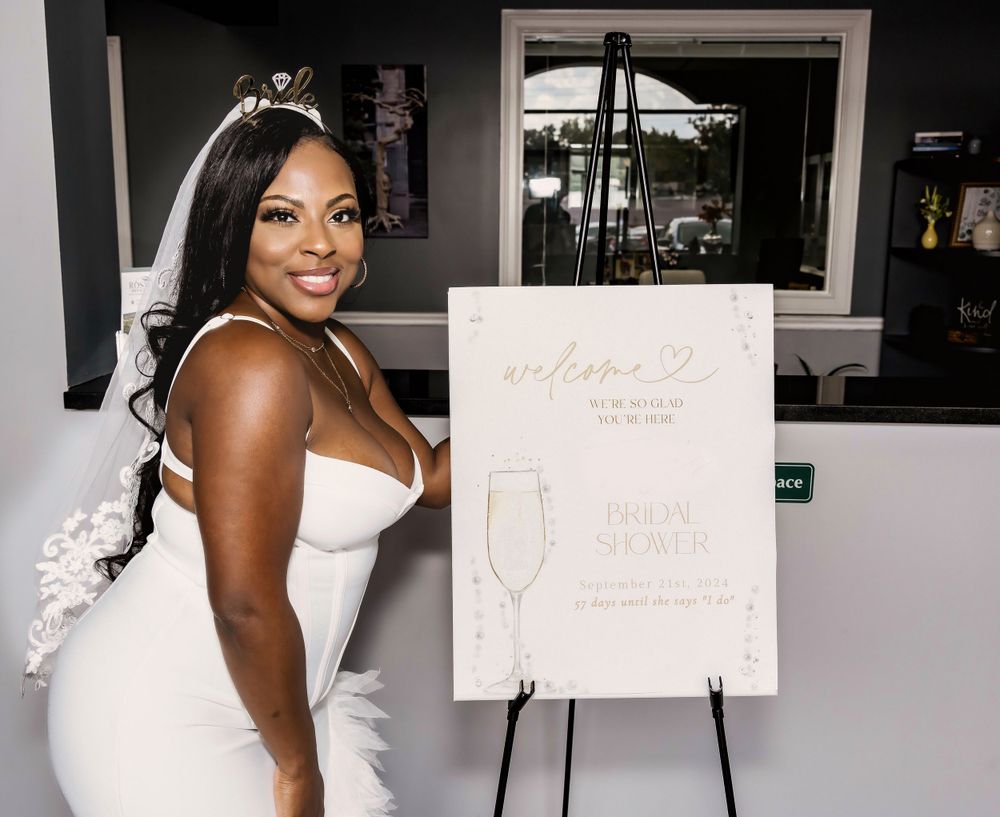 Wedding celebration setup with white easel display board and decor in indoor venue setting.