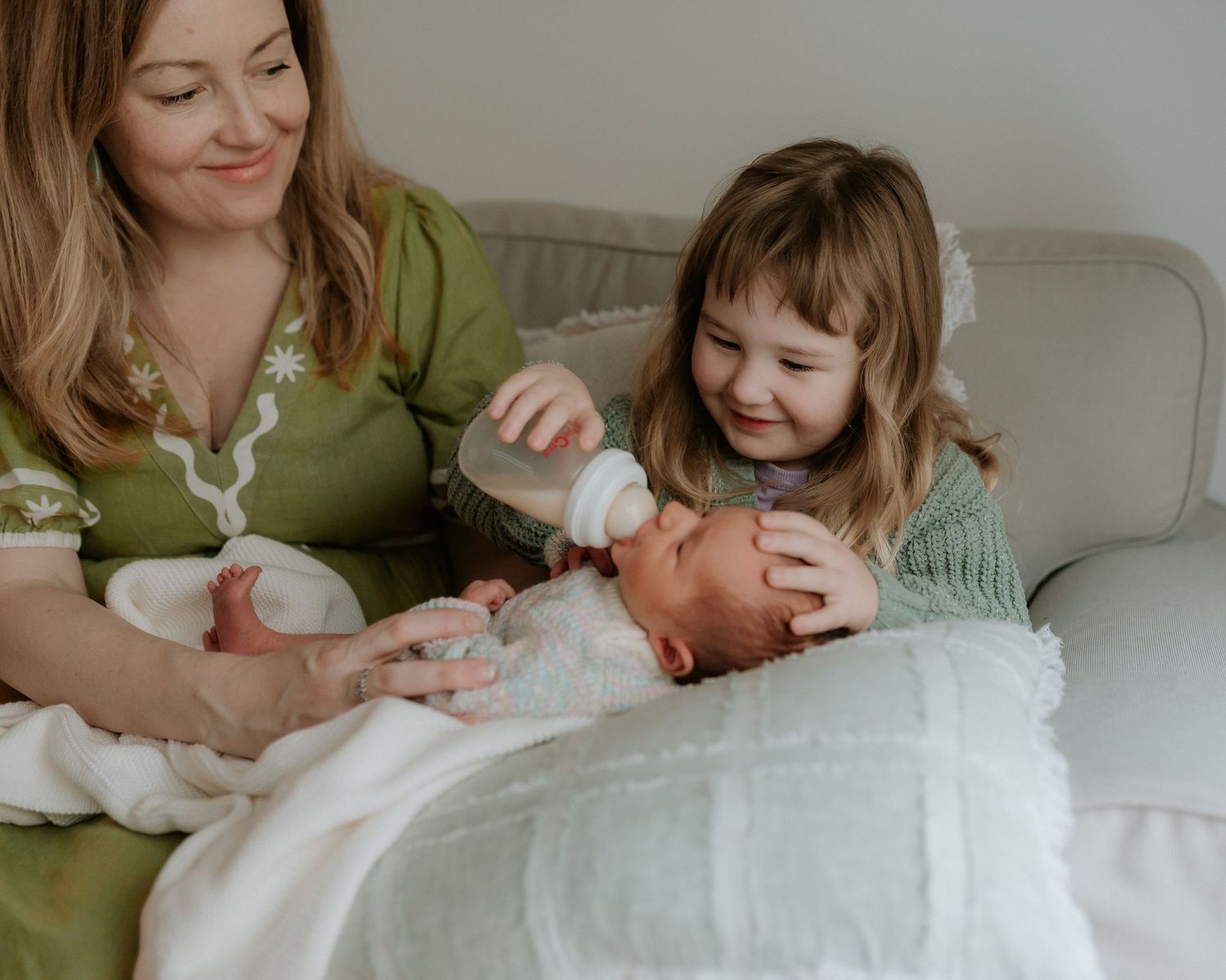Tender newborn photography session showing intimate family moments with a sleeping baby in soft lighting.