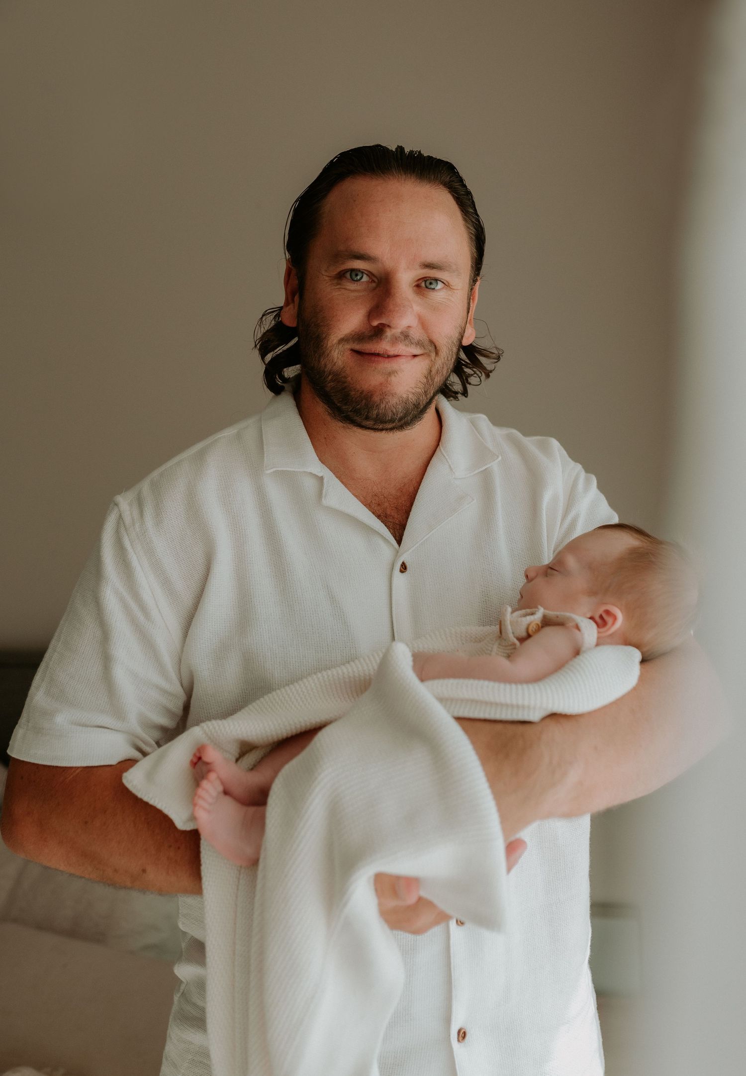 Series of intimate shots showing a newborn being held in a white room.