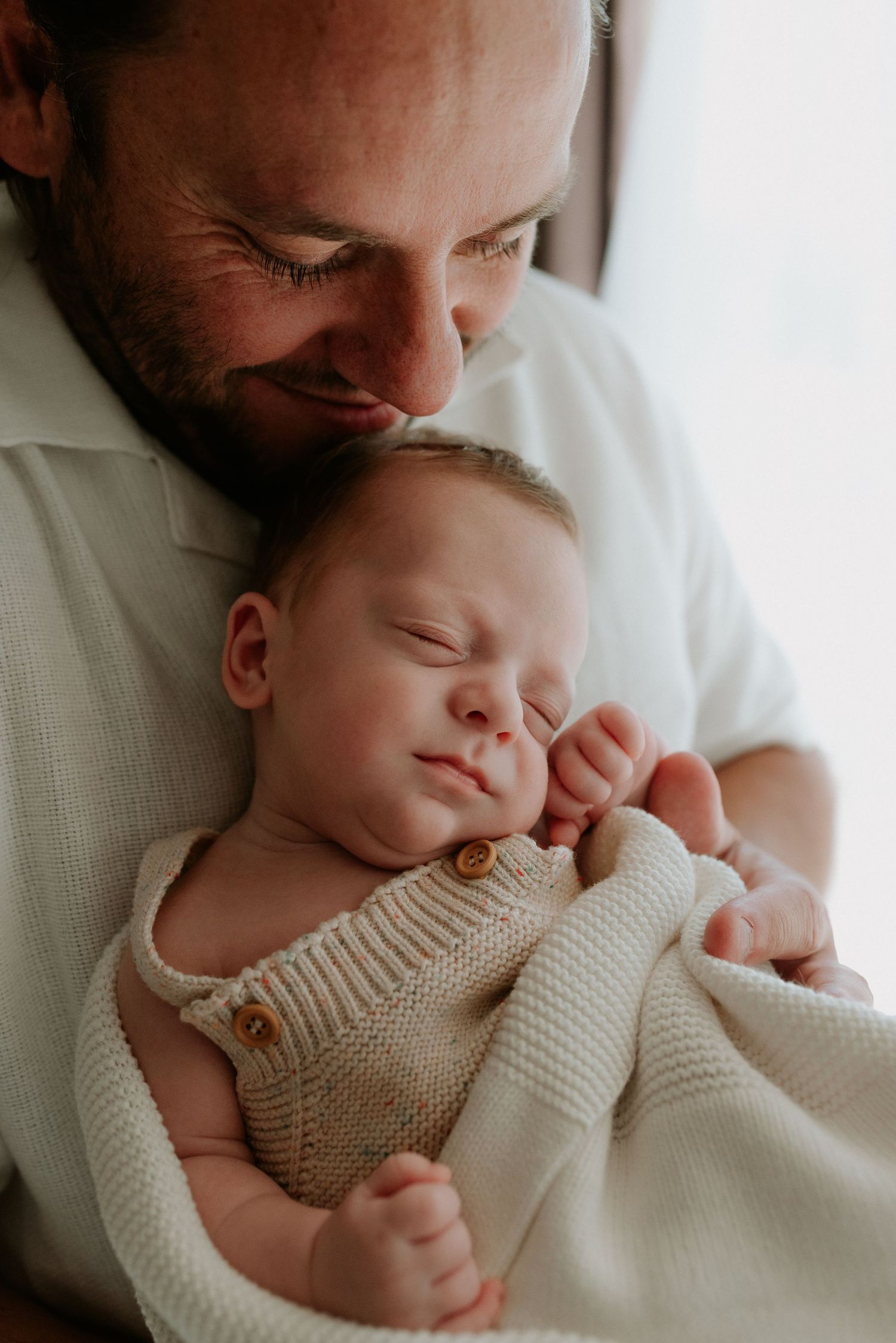 Sweet moments with a sleeping baby wrapped in a cozy knit sweater.