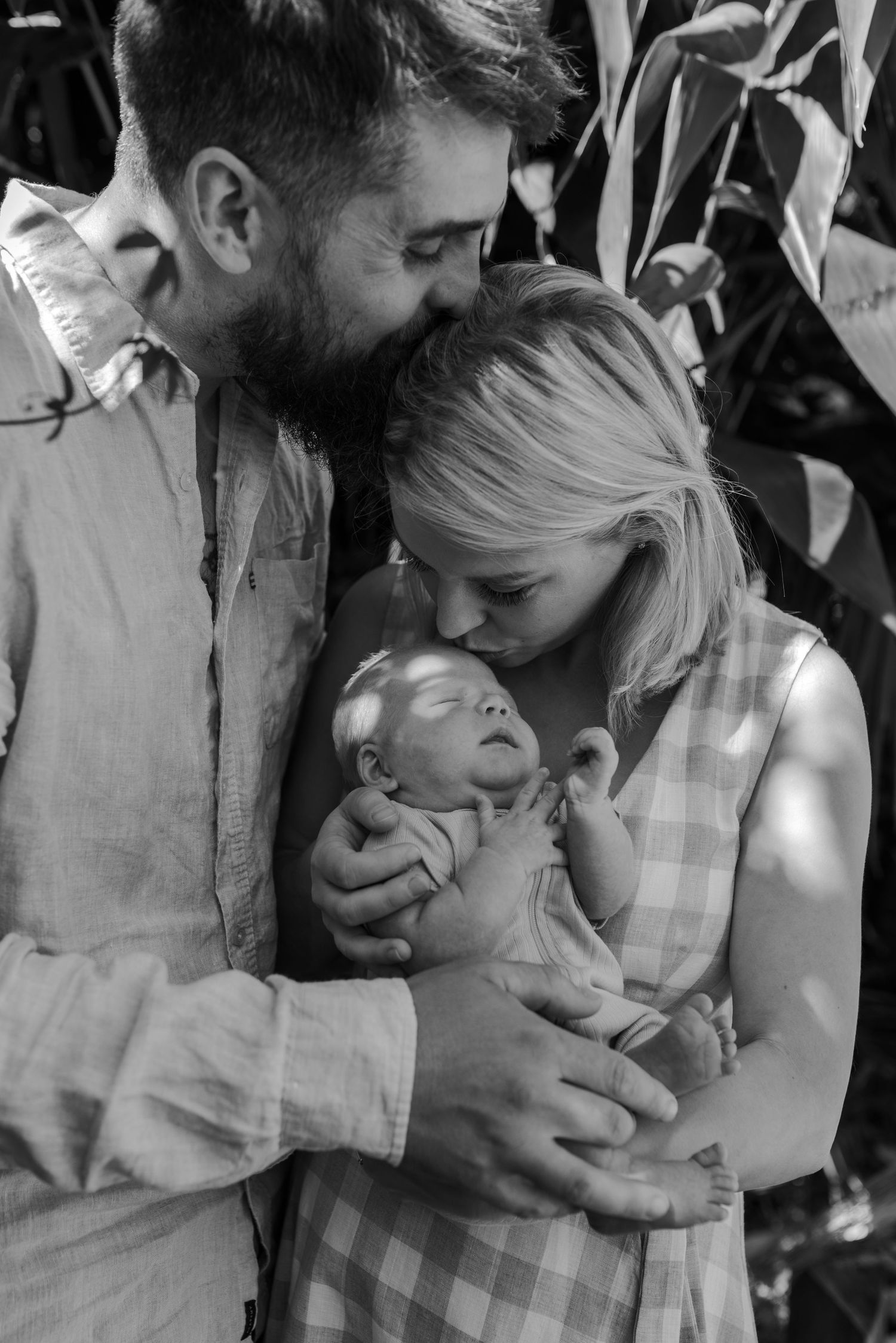 Intimate black and white family portrait showing tender moments of affection and love.