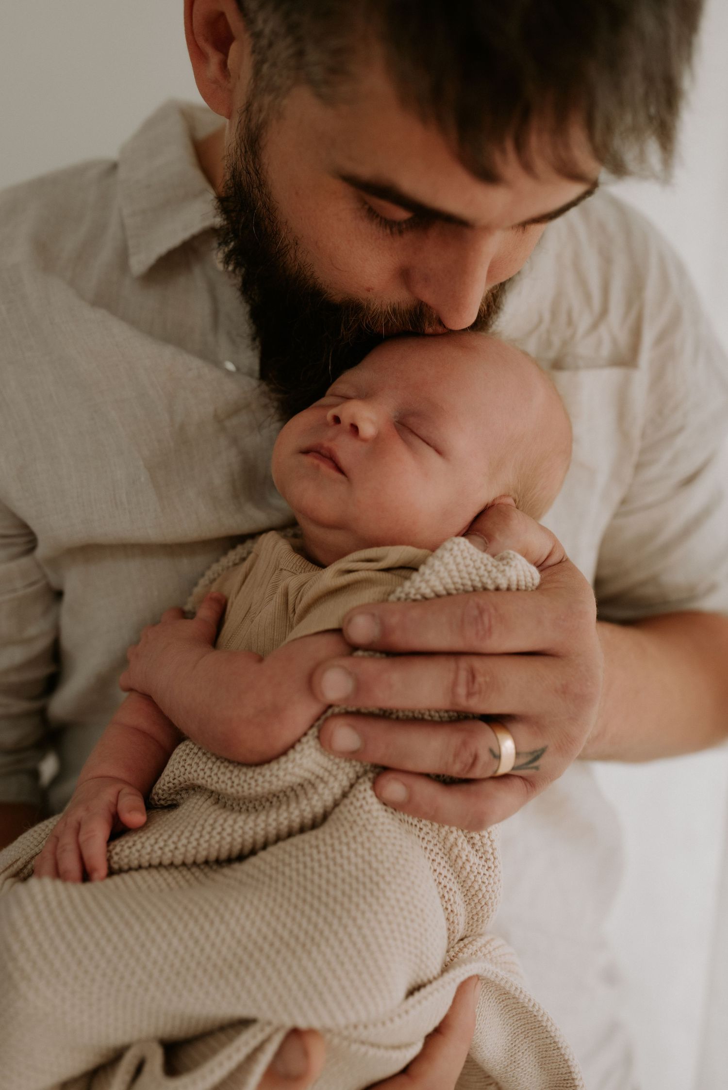 Gentle parental embrace with baby wearing soft knit clothing.