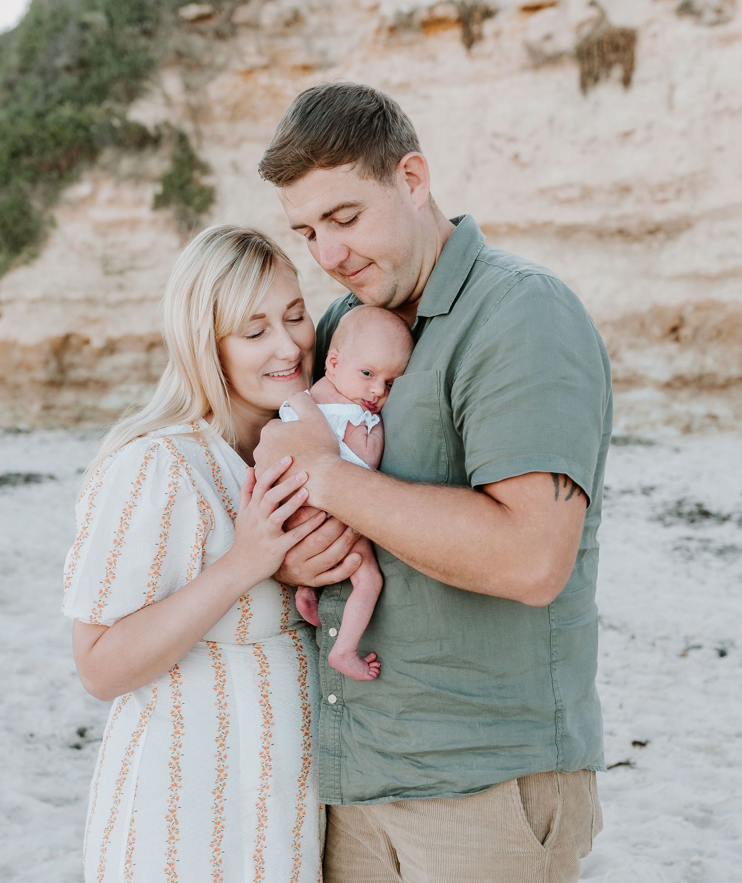 Intimate family portrait session on scenic beach with natural lighting.