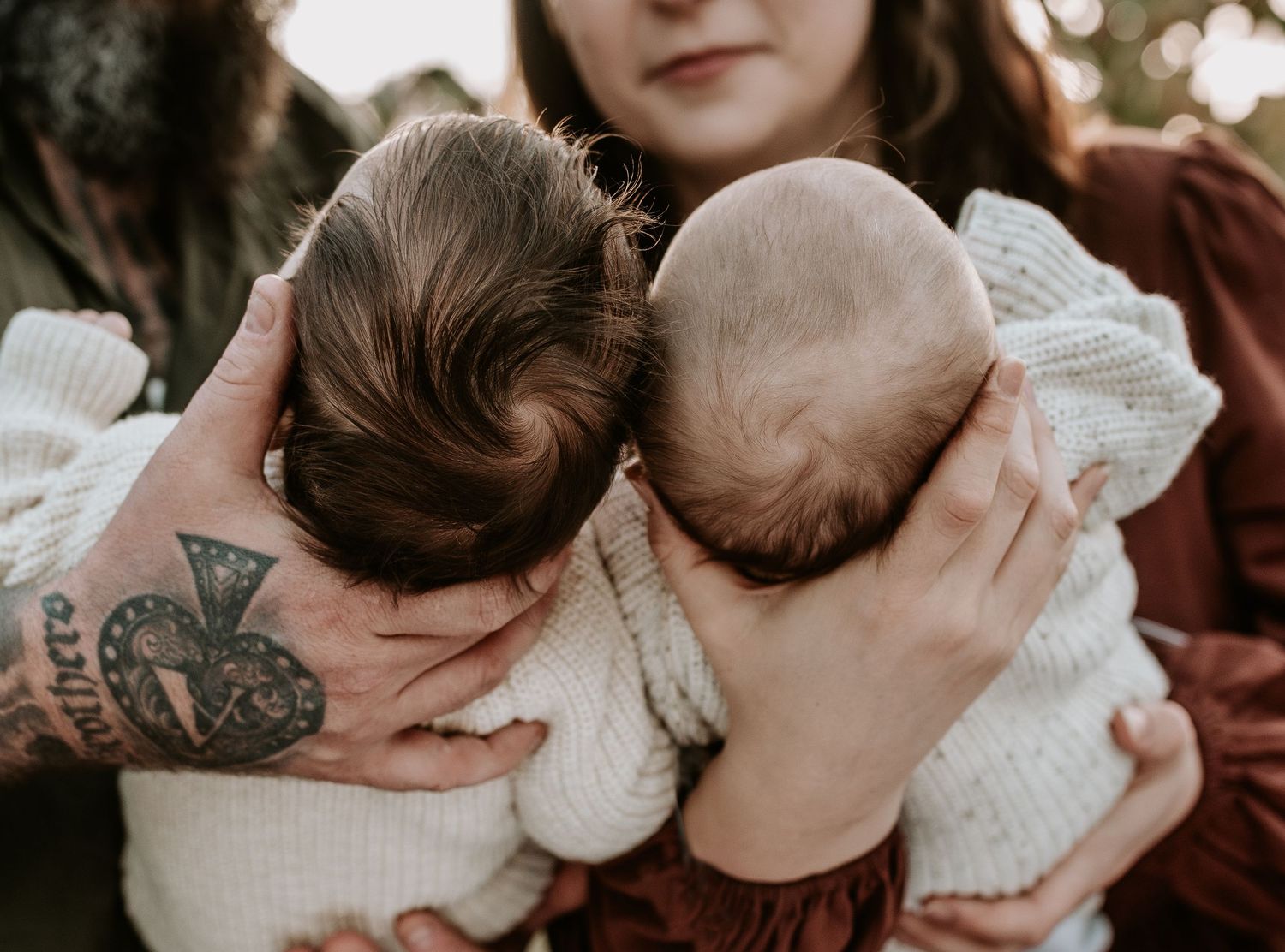 Intimate close-up shots showing tender family moments with a baby in white clothing.