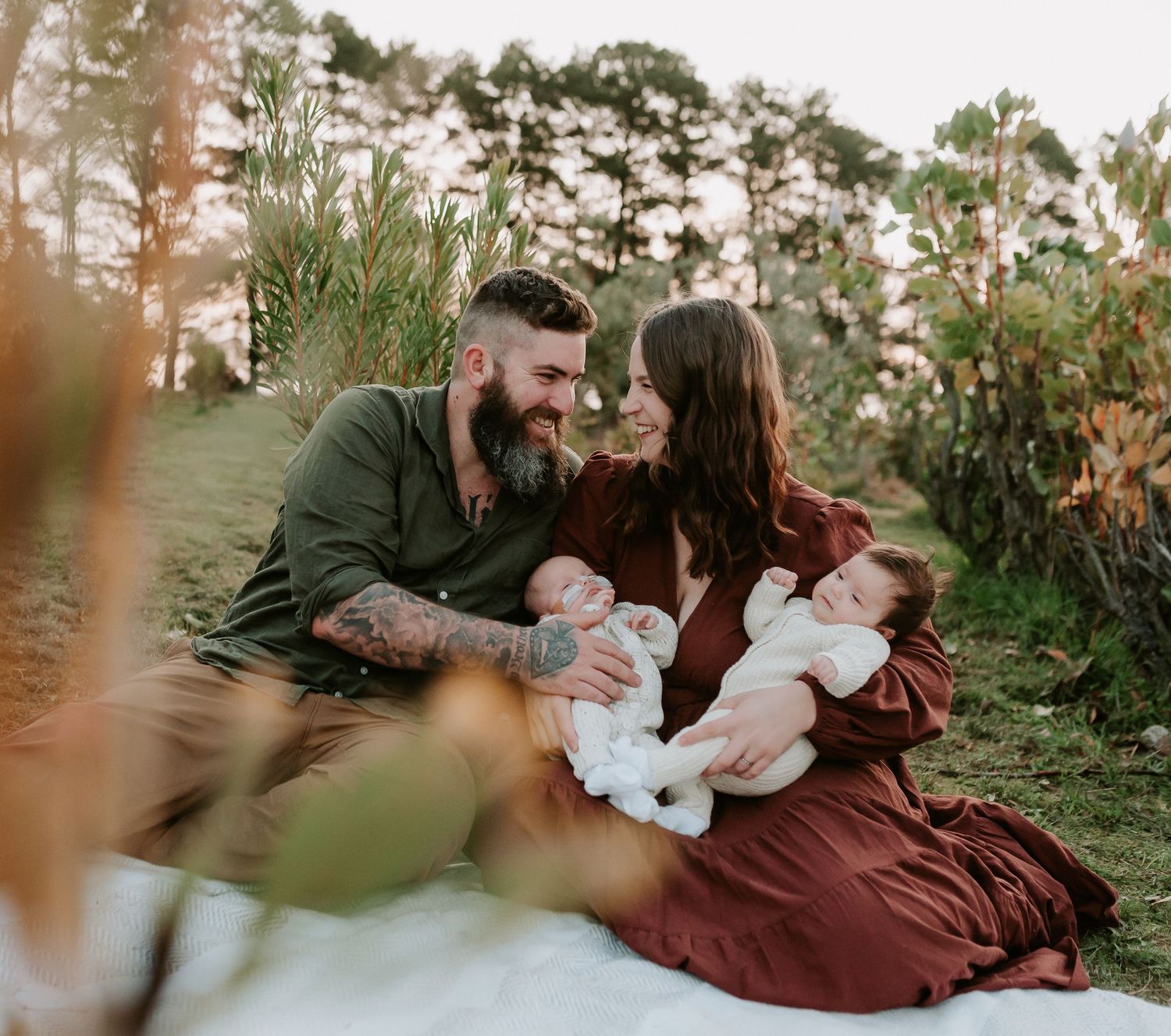 Family portrait session at sunset among trees and greenery.