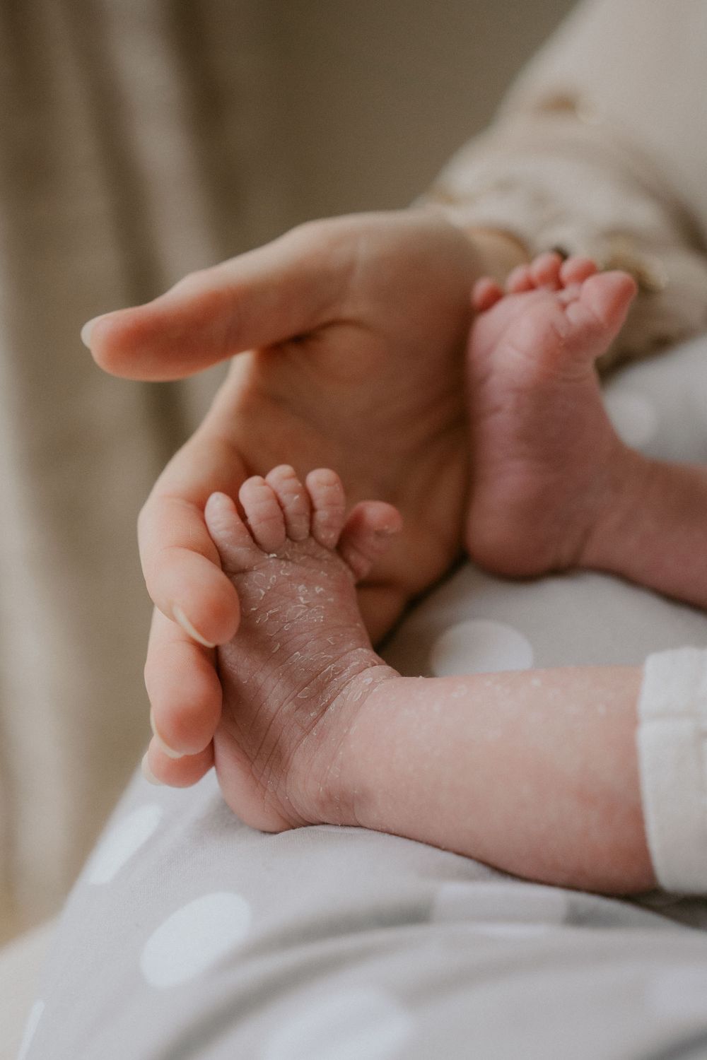 A mother touchinng the toes of her newborn baby