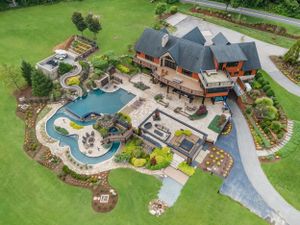 Aerial view of luxury property featuring custom pool, landscaping, and outdoor entertainment areas.
