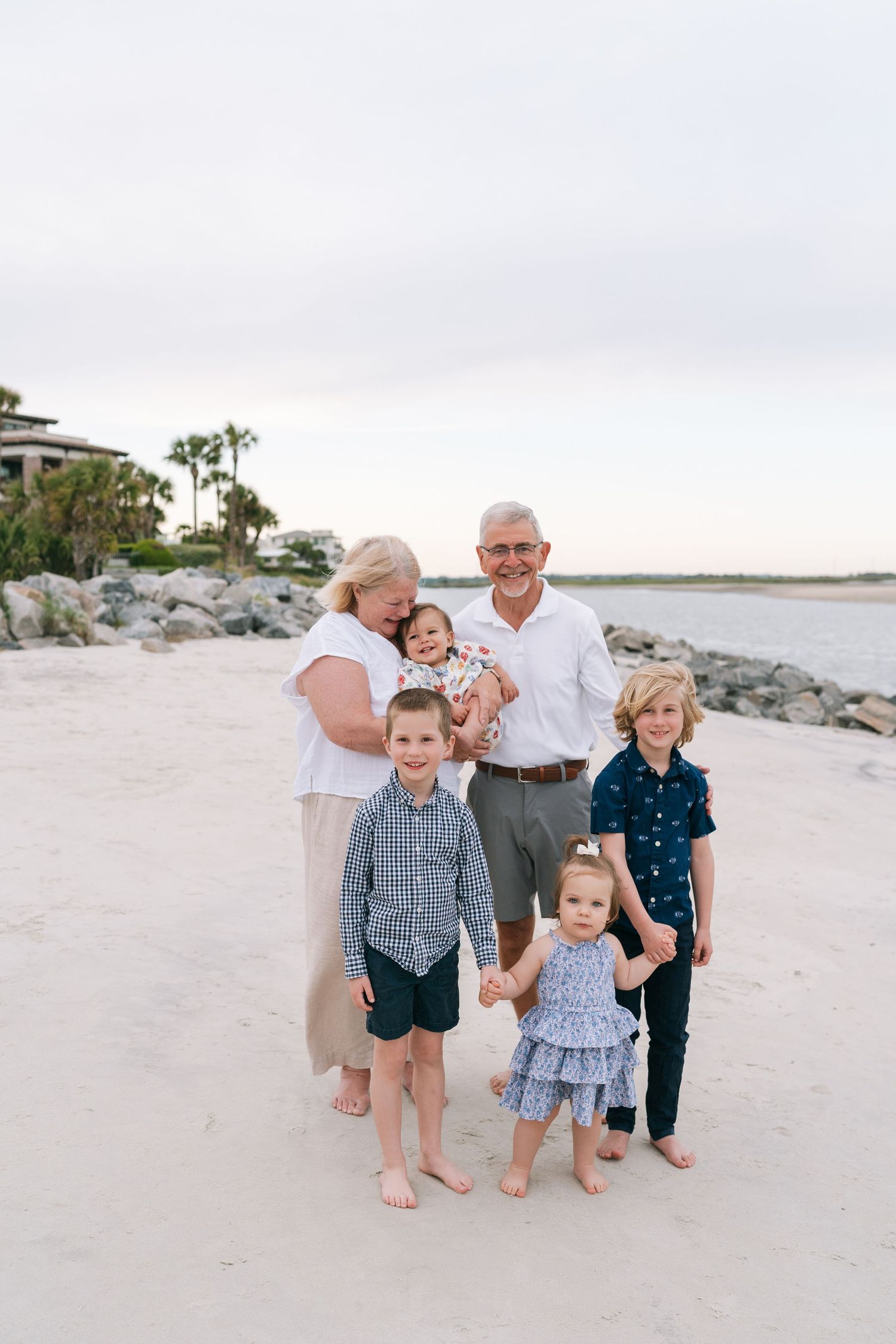 Three generations sharing a joyful family portrait on the Georgia coast during an extended family photo session.