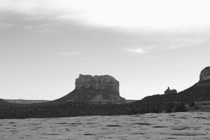Panoramic black and white landscape of rugged desert mesas and buttes under cloudy skies in Monument Valley.