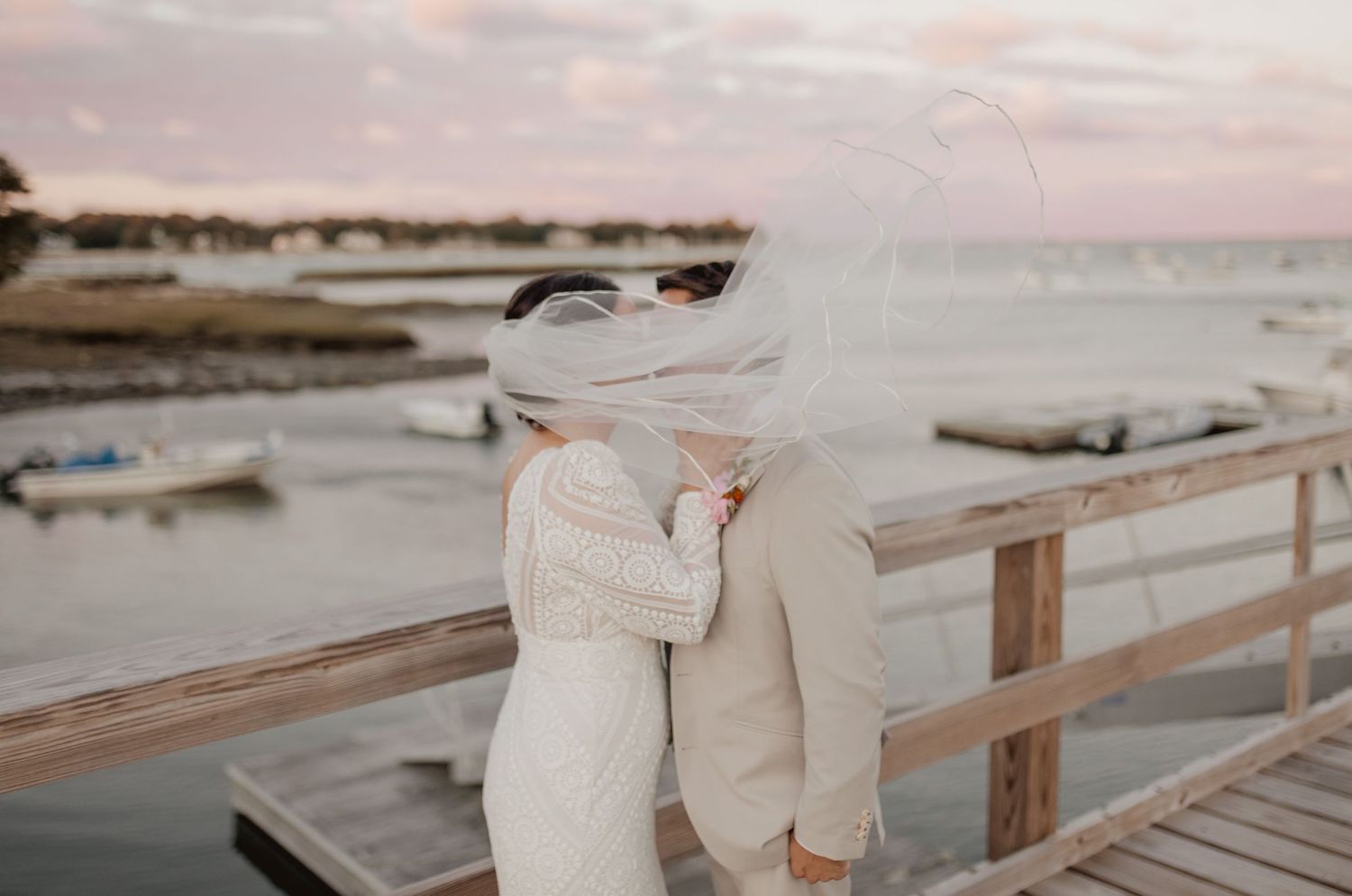 A romantic beachside wedding photoshoot with wooden boardwalk and sunset lighting.