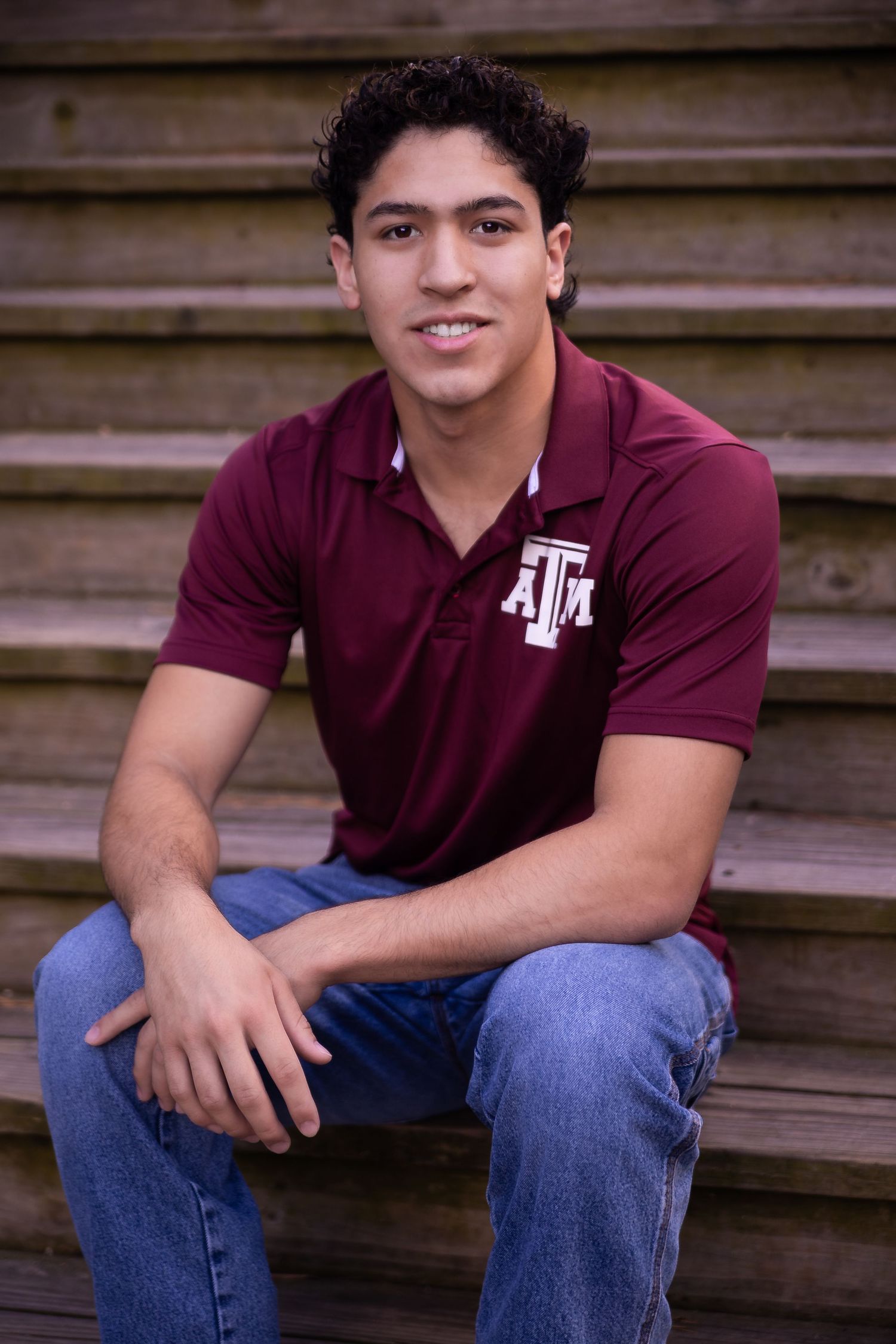 A Senior in a burgundy t-shirt during golden hour Houston Texas at Kickerillo Misher Preserve